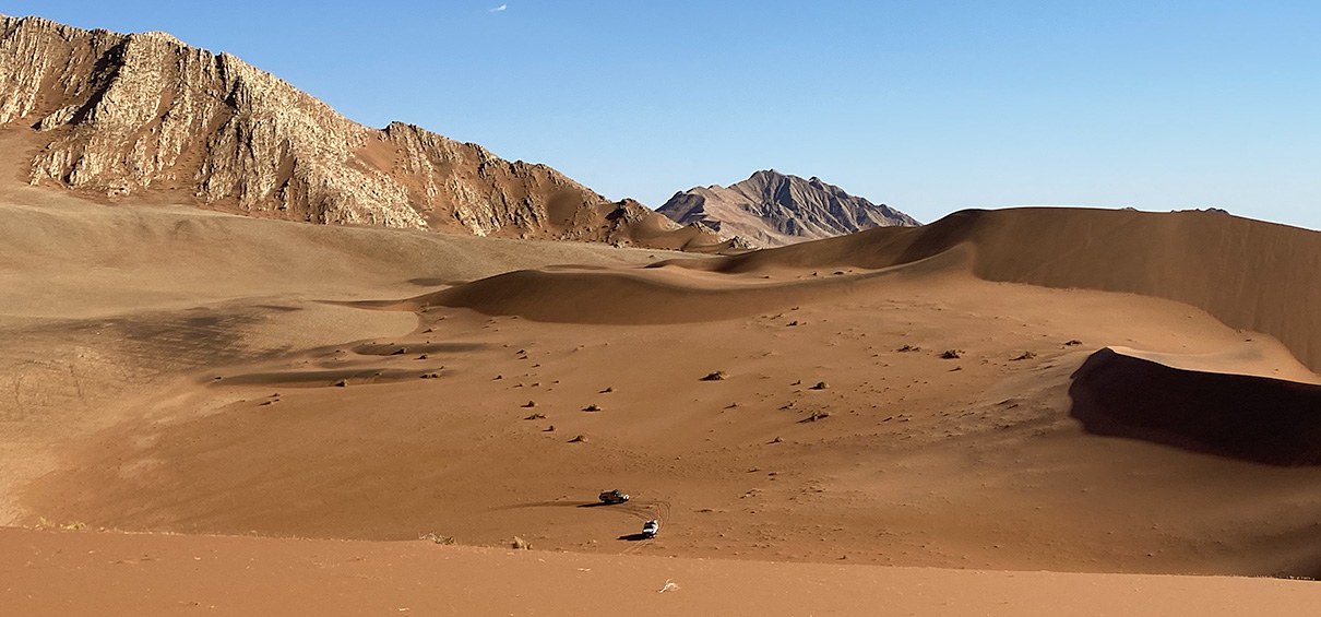 view of rocky mountains in the background, dunes in the foreground