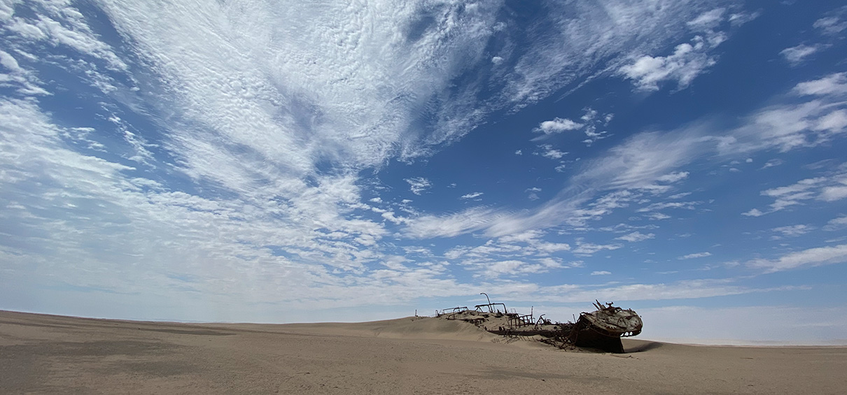 blue sky with clouds and shipwreck in the dune